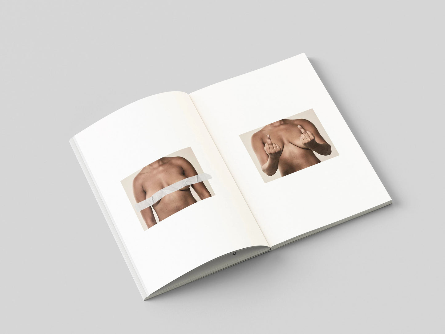 The Chests book open to a two-page spread of bare chest portraits with printed captions placed over the nipples